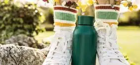 person wearing white and yellow floral rain boots